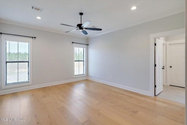 unfurnished room with baseboards, plenty of natural light, visible vents, and light wood-style floors