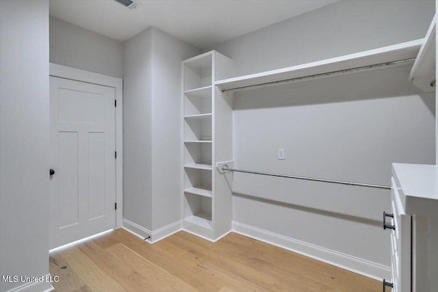 walk in closet with light wood-type flooring