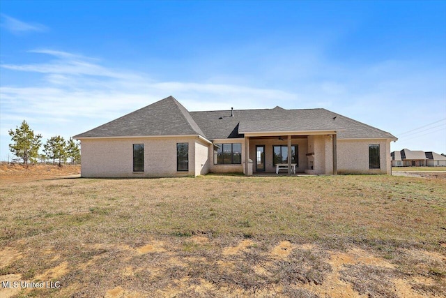 back of property with a yard and a patio area