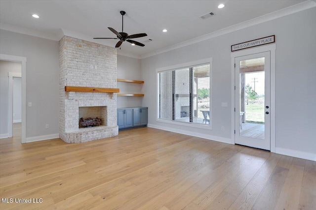 unfurnished living room with recessed lighting, a fireplace, visible vents, light wood finished floors, and crown molding