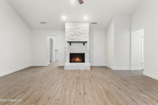 unfurnished living room featuring ceiling fan, a fireplace, and light hardwood / wood-style floors