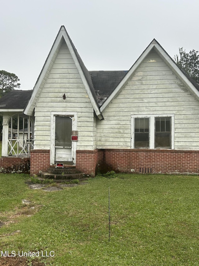 rear view of property with a yard