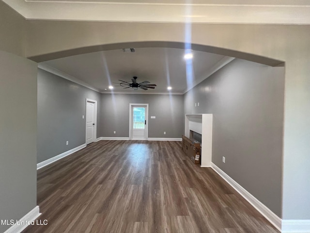 unfurnished living room featuring ornamental molding, ceiling fan, and dark wood-type flooring