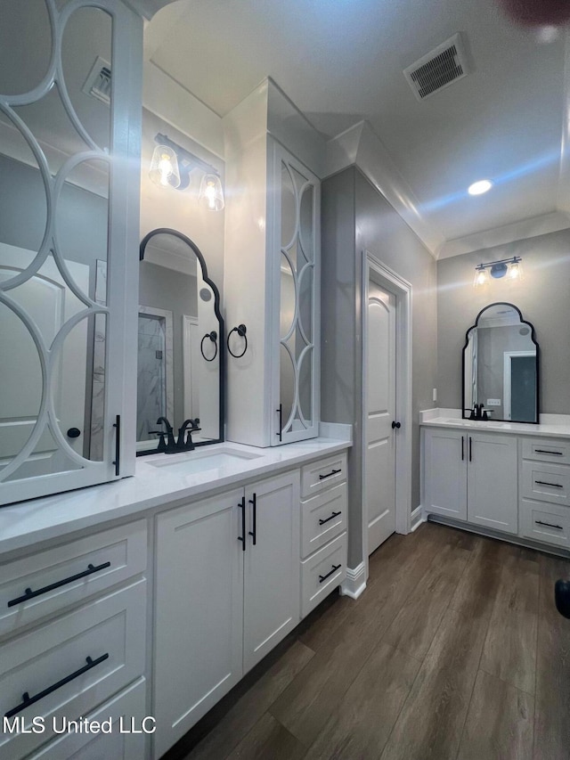 bathroom featuring vanity, wood-type flooring, and crown molding