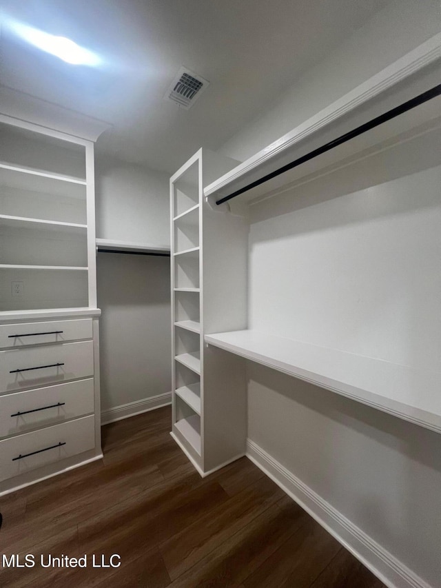 walk in closet with dark hardwood / wood-style floors