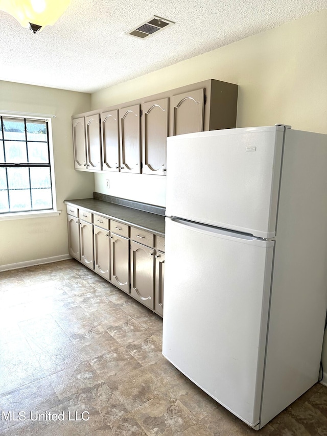 kitchen featuring a textured ceiling and white fridge