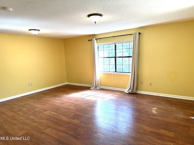 spare room with dark wood-type flooring and a textured ceiling