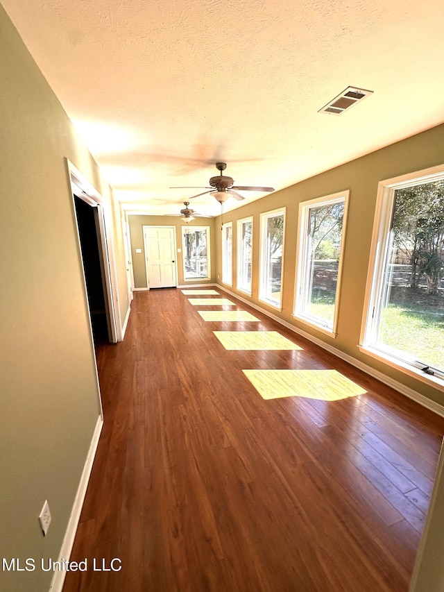 unfurnished room featuring ceiling fan, wood-type flooring, and a textured ceiling