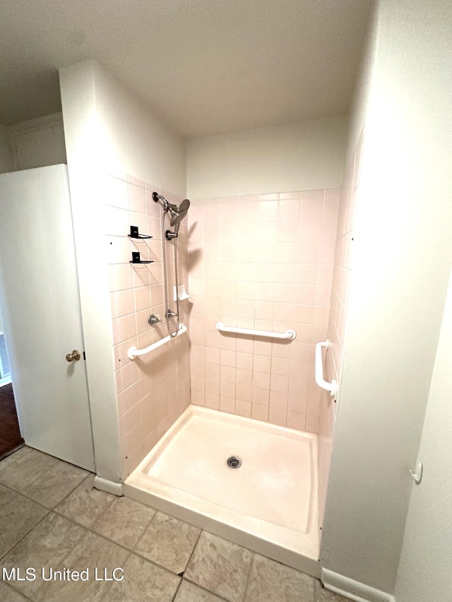 bathroom with tile patterned floors and tiled shower