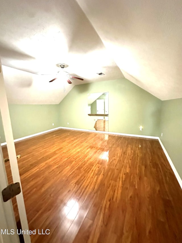 additional living space with lofted ceiling, hardwood / wood-style floors, and ceiling fan