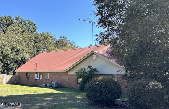 view of property exterior featuring central AC and a yard