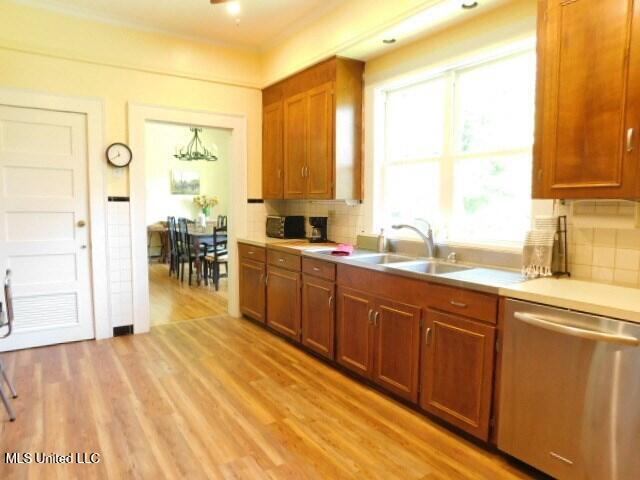 125 Riverside St, Vidalia, LA 71373 - kitchen with tasteful backsplash, light countertops, a sink, light wood-type flooring, and dishwasher