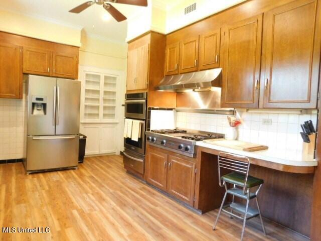 125 Riverside St, Vidalia, LA 71373 - kitchen featuring brown cabinets, visible vents, appliances with stainless steel finishes, light wood-style floors, and under cabinet range hood