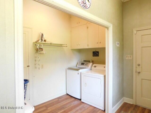 125 Riverside St, Vidalia, LA 71373 - laundry room featuring cabinet space, washing machine and dryer, baseboards, and light wood-style floors