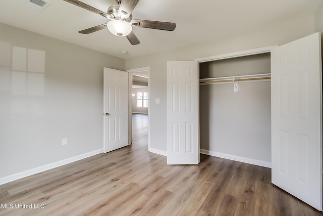 unfurnished bedroom featuring hardwood / wood-style flooring, ceiling fan, and a closet