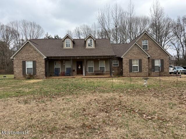 view of front of house with a front yard and covered porch