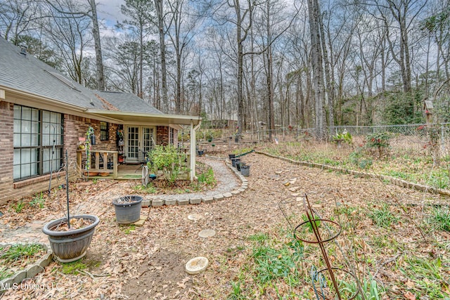 view of yard featuring french doors and fence