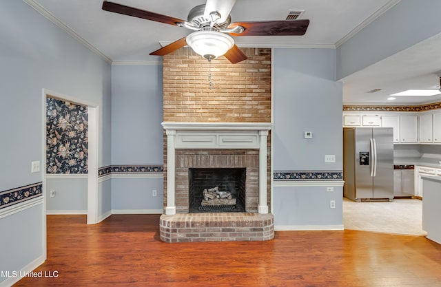 unfurnished living room with light wood-style floors, a fireplace, and crown molding