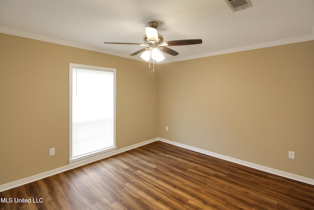 empty room featuring a wealth of natural light, dark hardwood / wood-style floors, and ornamental molding