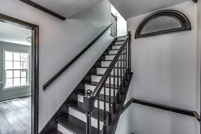 stairway featuring hardwood / wood-style flooring and a textured ceiling