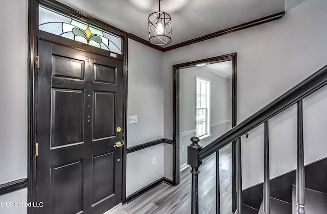 entryway with light hardwood / wood-style flooring and ornamental molding