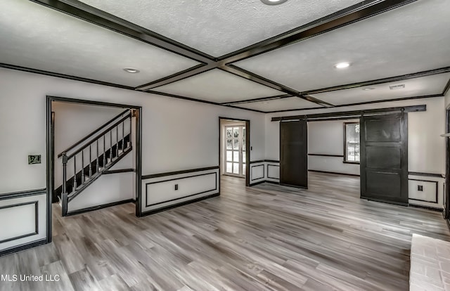 unfurnished living room with light hardwood / wood-style floors, a textured ceiling, and plenty of natural light