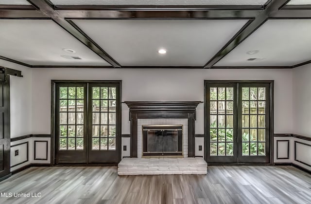 unfurnished living room with light hardwood / wood-style flooring, french doors, and coffered ceiling