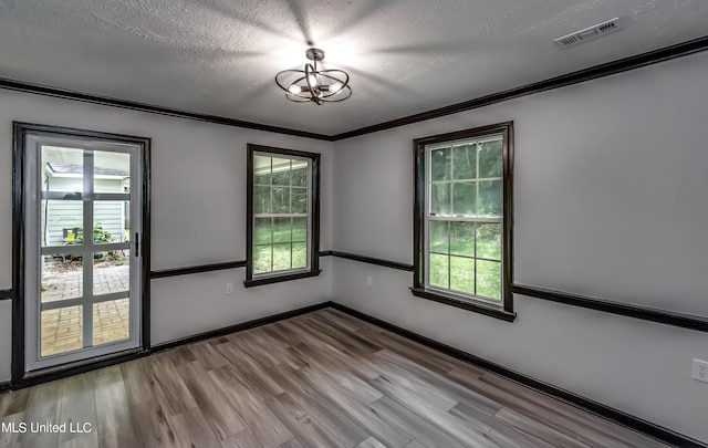 unfurnished room featuring ornamental molding, a textured ceiling, and light wood-type flooring