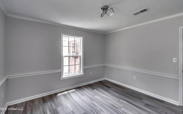 empty room with hardwood / wood-style floors and crown molding