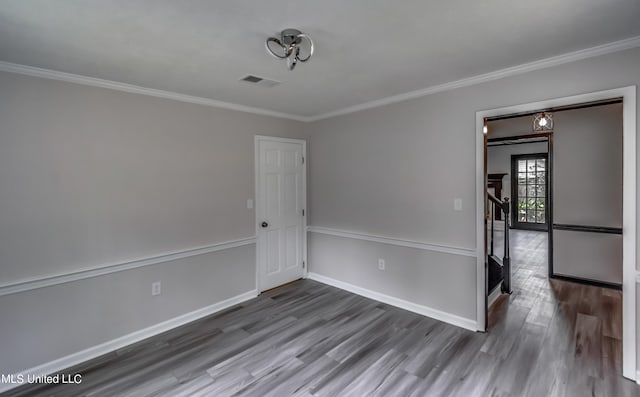 spare room with ornamental molding and hardwood / wood-style floors