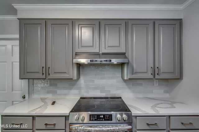 kitchen with gray cabinetry, light stone counters, ornamental molding, and stainless steel range