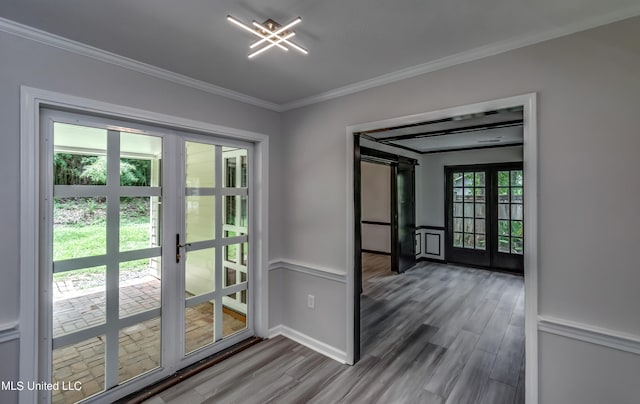 doorway with french doors, wood-type flooring, plenty of natural light, and crown molding