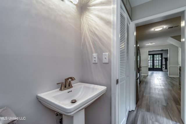 bathroom with french doors, sink, and hardwood / wood-style floors