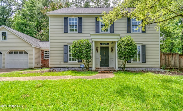 colonial home featuring a front yard and a garage