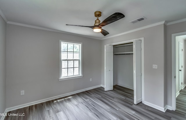 unfurnished bedroom with a closet, ceiling fan, hardwood / wood-style flooring, and crown molding