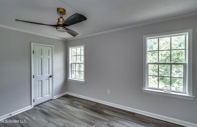 empty room featuring ornamental molding, hardwood / wood-style flooring, and a healthy amount of sunlight