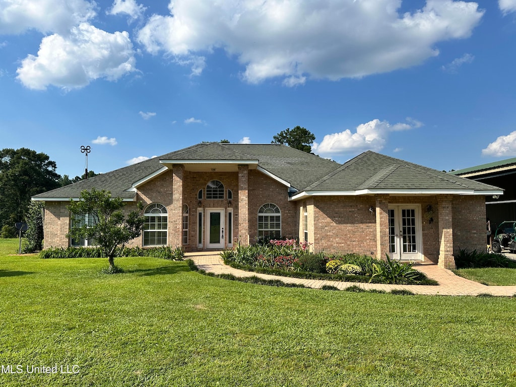 single story home with french doors and a front lawn