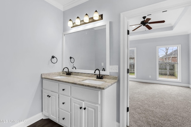 full bath featuring baseboards, double vanity, a sink, and crown molding