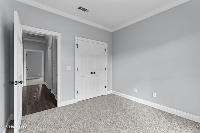 unfurnished bedroom with baseboards, carpet floors, visible vents, and crown molding