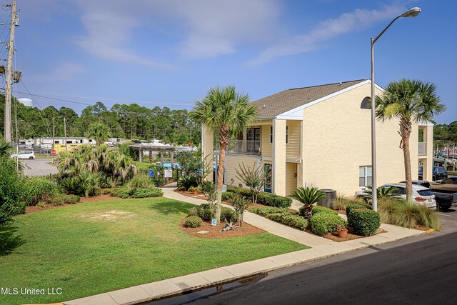 2421 Beachview Dr Unit F16, Ocean Springs, MS 39564 - view of property exterior featuring a yard and stucco siding