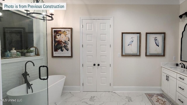 220 W Ave, Long Beach, MS 39560 - bathroom featuring a chandelier, marble look tile flooring, vanity, baseboards, and a freestanding tub