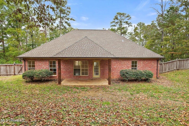 rear view of property featuring a yard and a patio