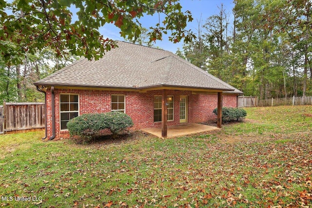 back of house featuring a lawn and a patio