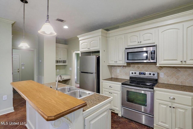 kitchen with ornamental molding, sink, a kitchen island with sink, tasteful backsplash, and stainless steel appliances