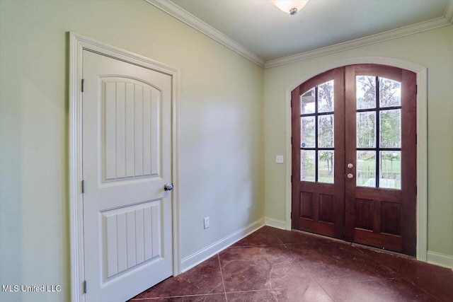 foyer with crown molding, dark tile patterned floors, and french doors