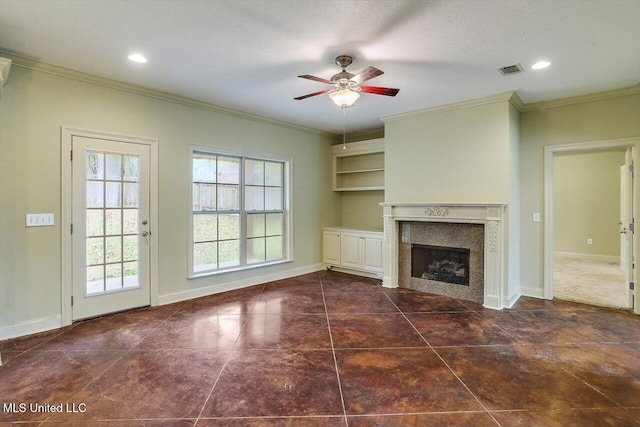 unfurnished living room featuring ceiling fan, dark tile patterned floors, a textured ceiling, and ornamental molding