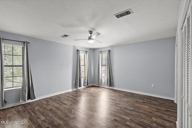 unfurnished room featuring dark wood-type flooring, a textured ceiling, and ceiling fan