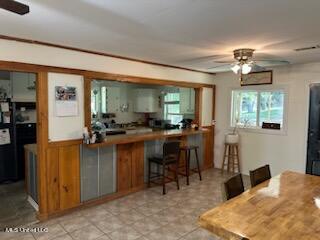 kitchen featuring a kitchen breakfast bar, ceiling fan, and kitchen peninsula