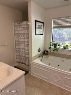 bathroom with tile patterned flooring, vanity, and a tub