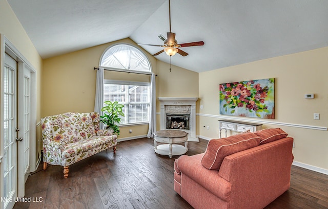 living room featuring baseboards, a ceiling fan, lofted ceiling, dark wood-style flooring, and a fireplace